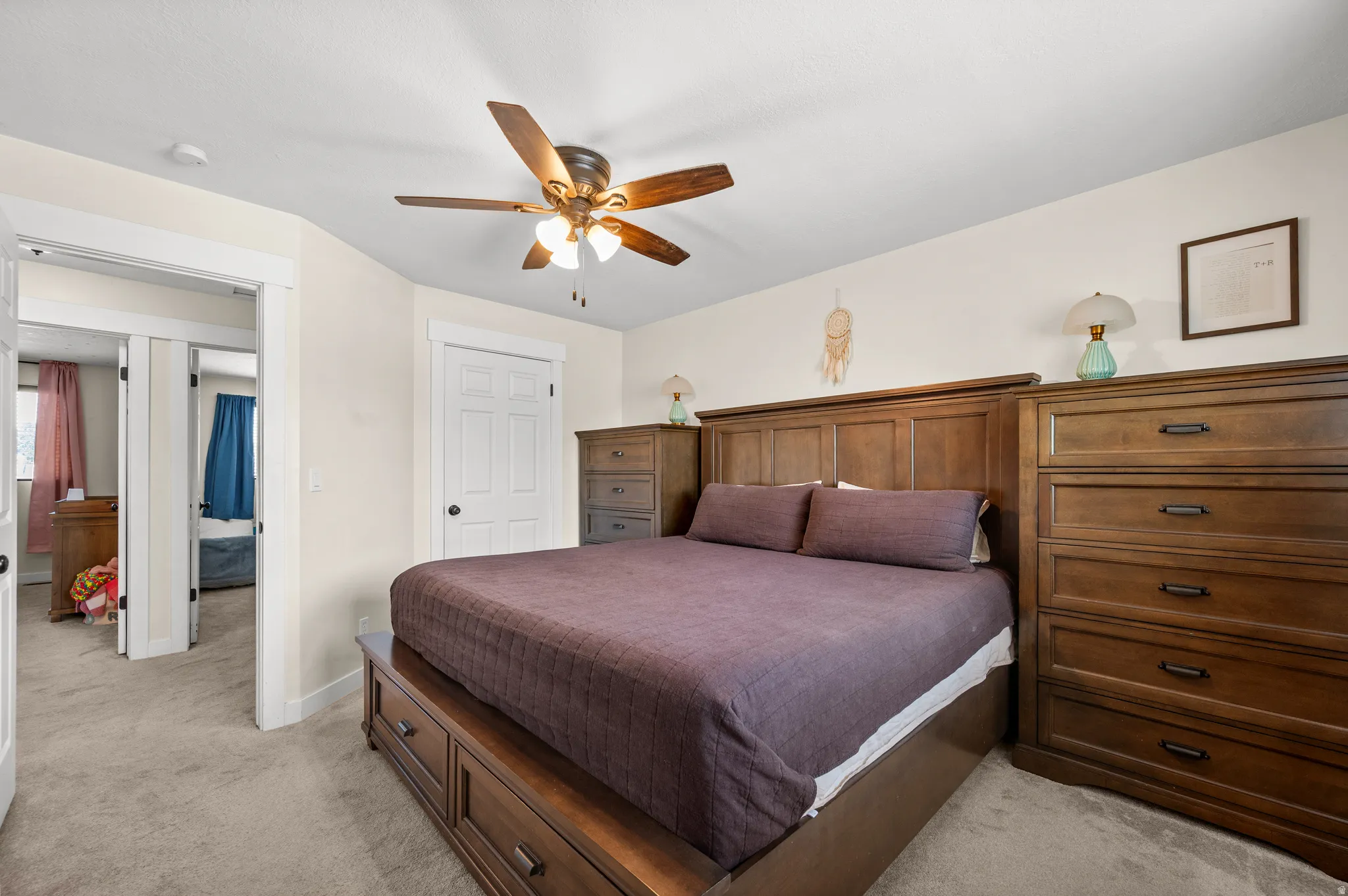 Carpeted room featuring a ceiling fan, white trim, and a paneled door