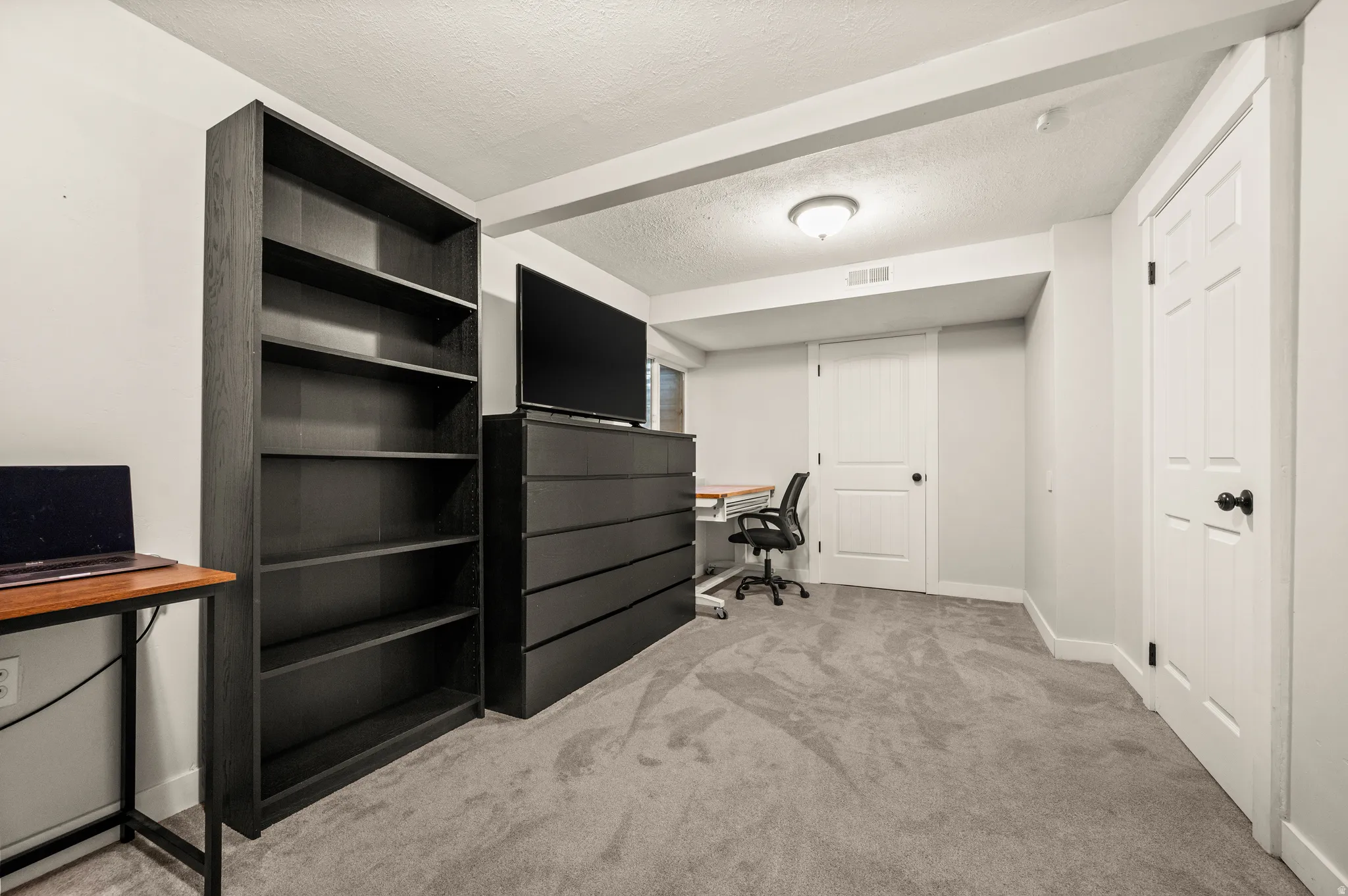 Carpeted interior space featuring white walls and multiple panel doors