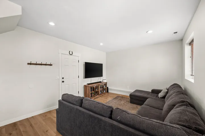 Open living area with recessed lighting and wood-finish flooring