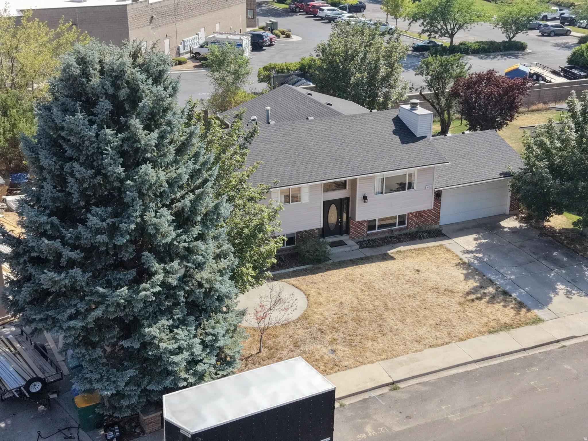 Contemporary single-story residence featuring a charcoal-gray asphalt roof, brick and stucco exterior, and a spacious front-facing lawn