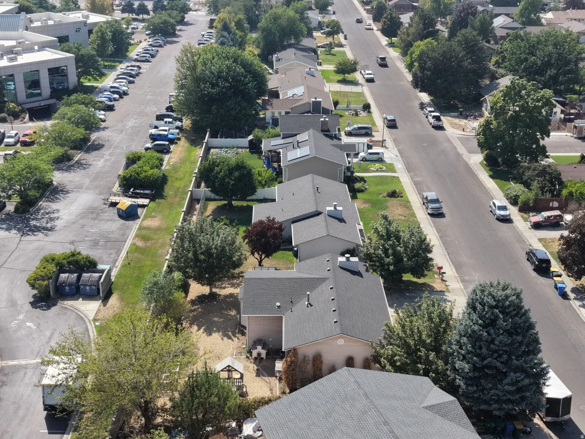 Aerial perspective showcasing this residential property positioned on a tree-lined street within an established neighborhood