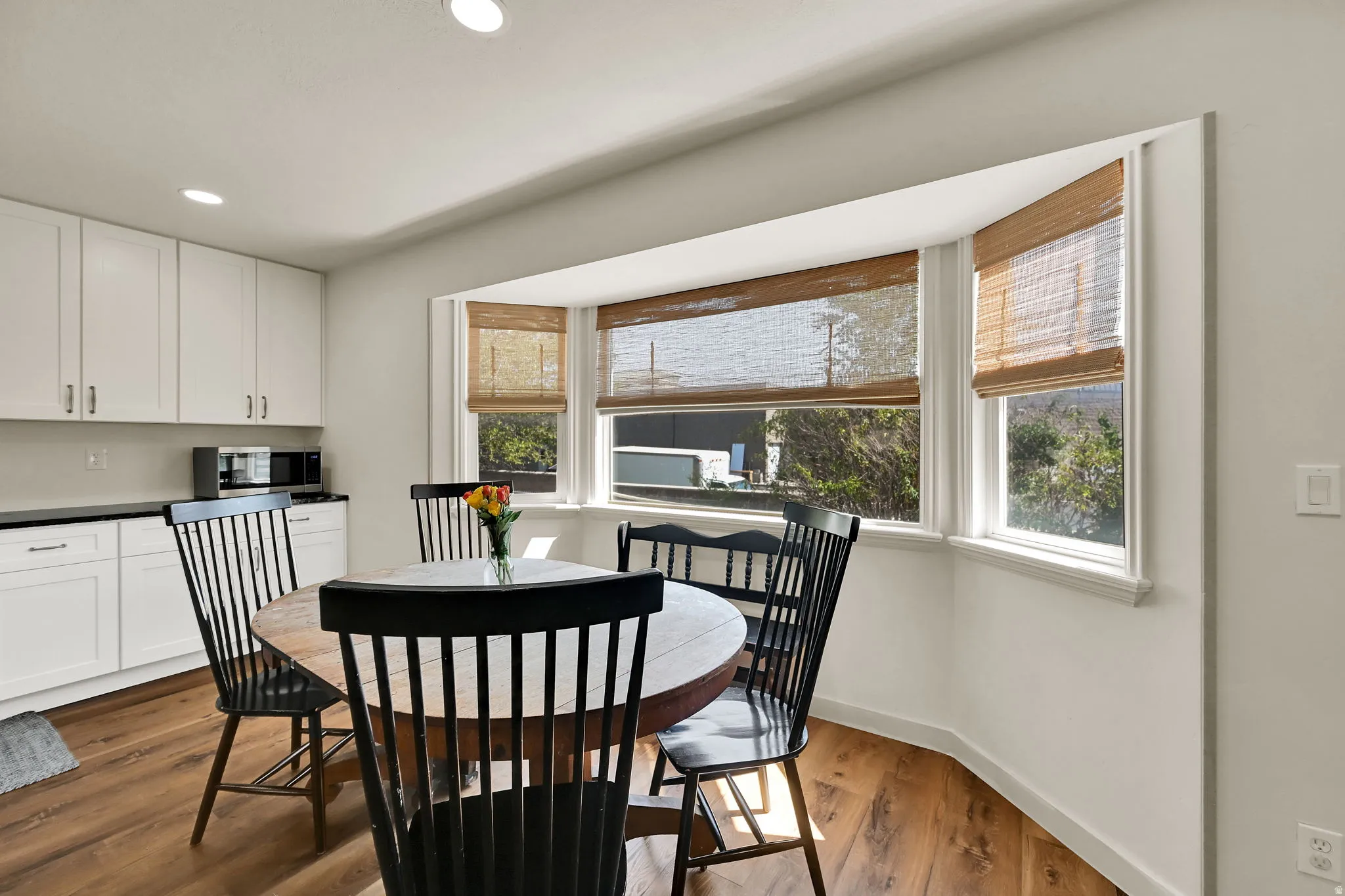 Bright dining area with expansive multi-pane windows framing natural light and outdoor scenery