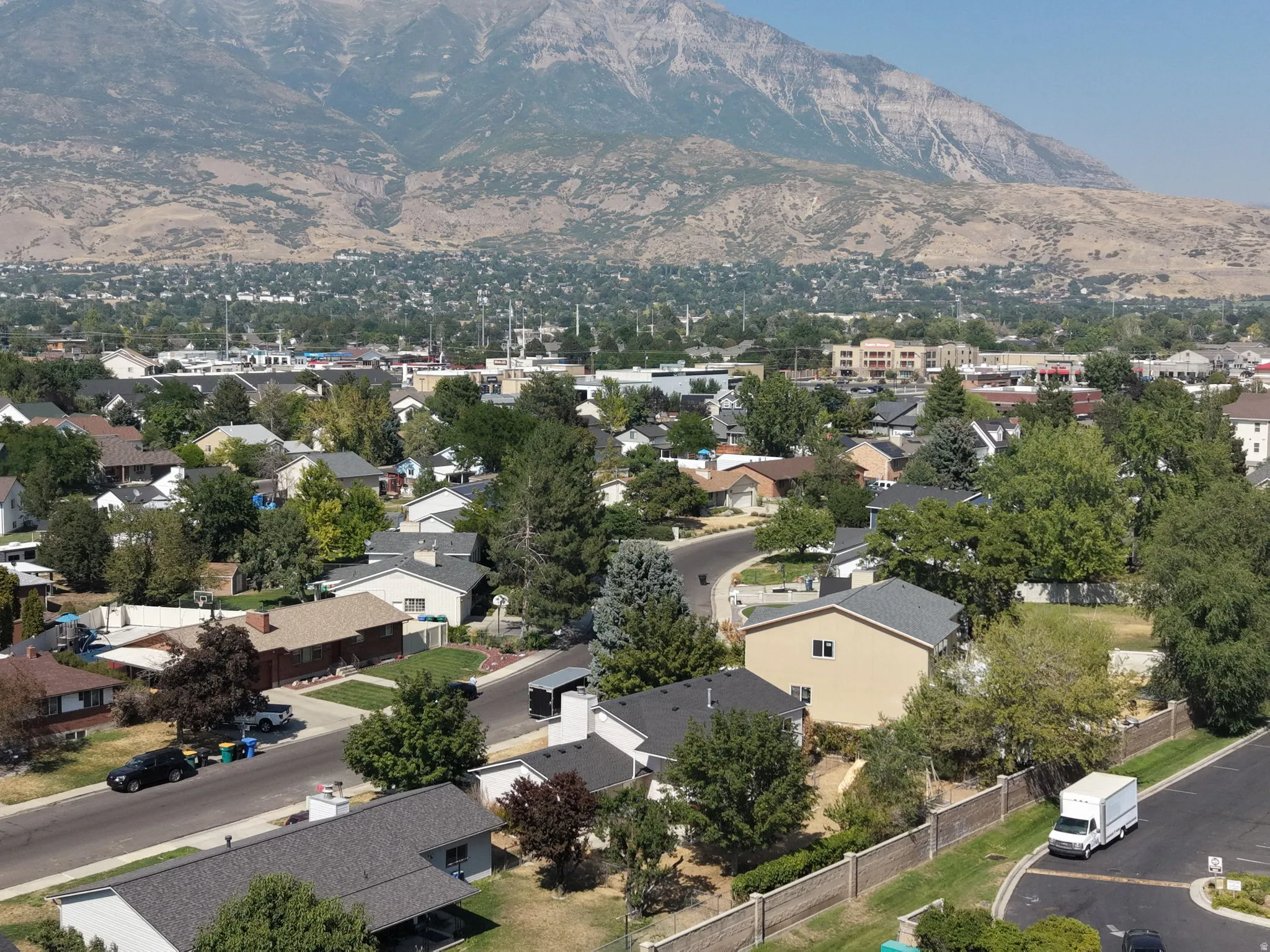 Established neighborhood featuring single-family residences with mature landscaping, tree-lined streets, and a dramatic mountain backdrop