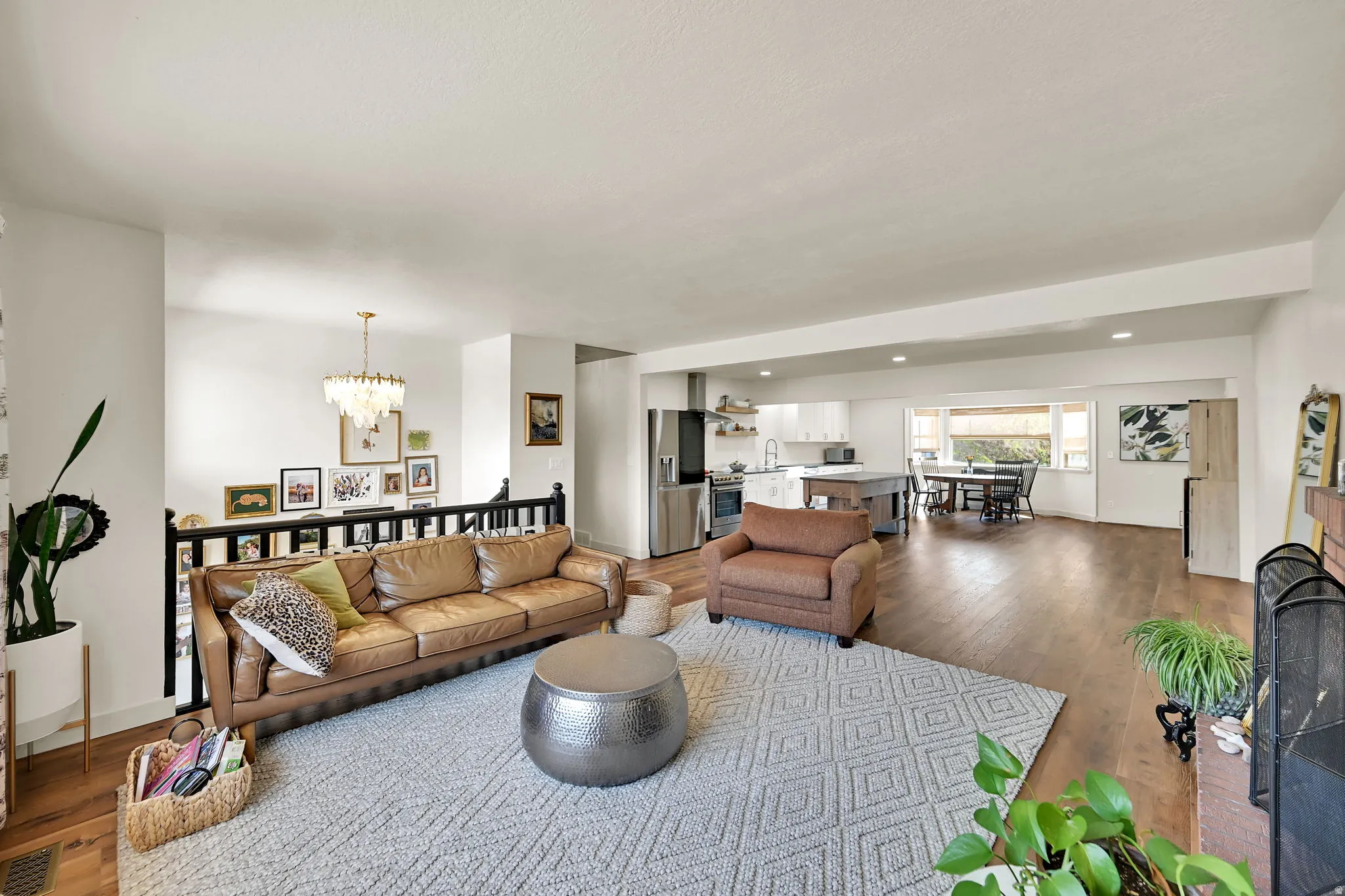 Open-concept living area with hardwood flooring, recessed ceiling lighting, and abundant natural light