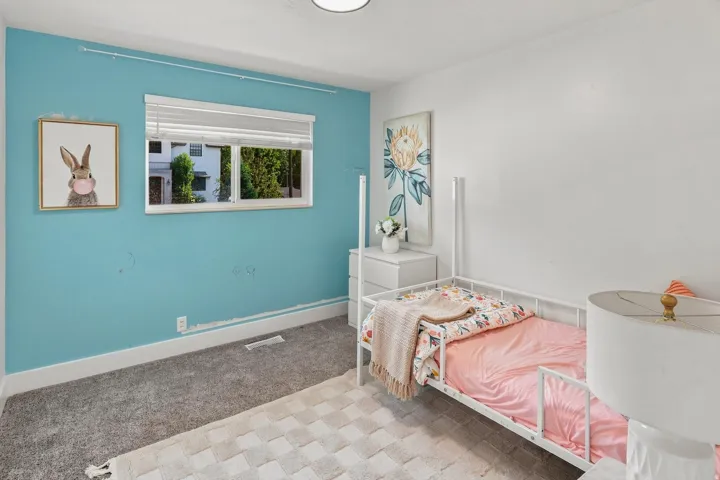 Carpeted flooring, white trim, and a window with blinds