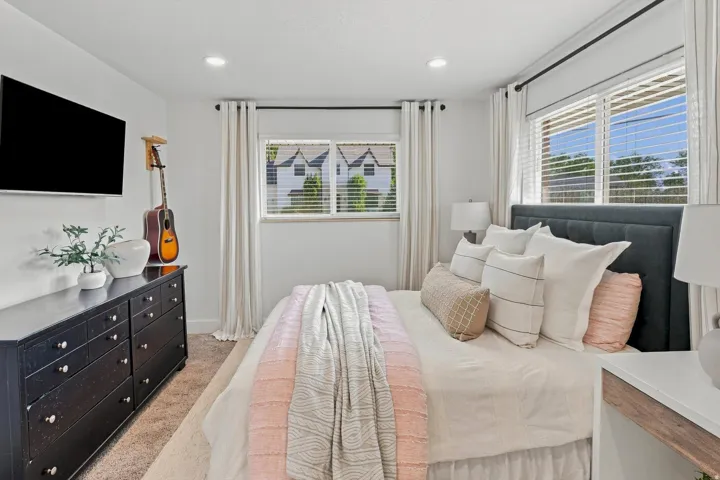 Recessed lighting illuminates the space, featuring window blinds and curtains