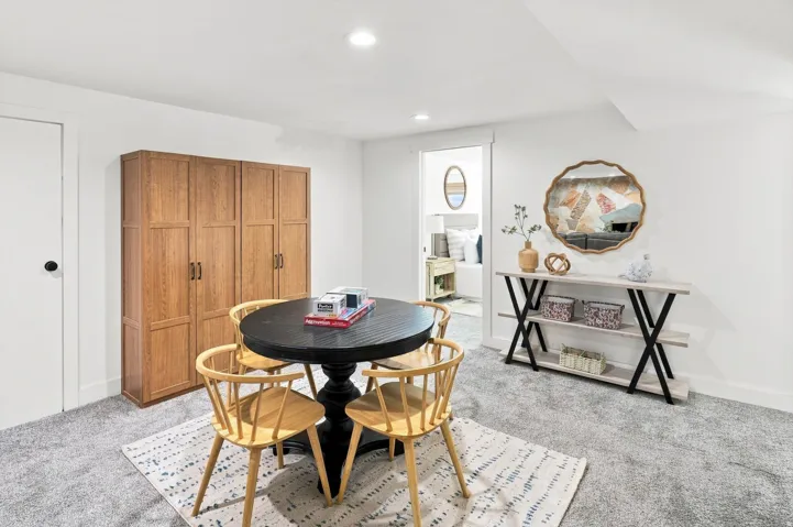 Recessed lighting, wood-finish built-in cabinetry, neutral wall paint, and gray carpeting