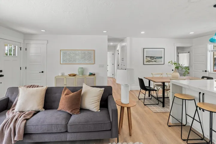Open concept living area with wood-finish flooring, recessed lighting, and white walls