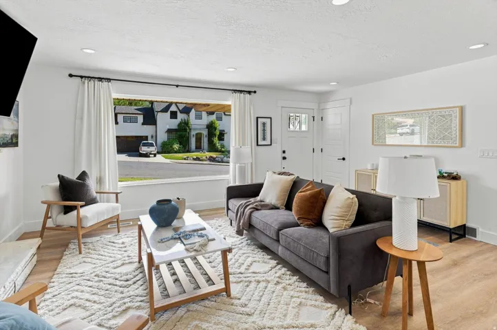 Spacious living area featuring wood-finish flooring, recessed lighting, and large windows