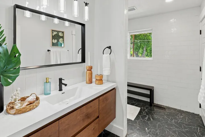 Floating wood-finish vanity with an integrated rectangular sink and matte black faucet