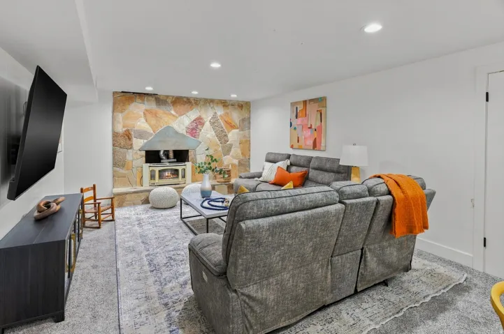 Stone accent wall featuring a wood-burning stove