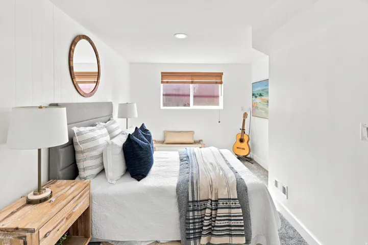 White shiplap accent wall, recessed lighting, window with wood blinds, built-in window bench, and wood-finish flooring