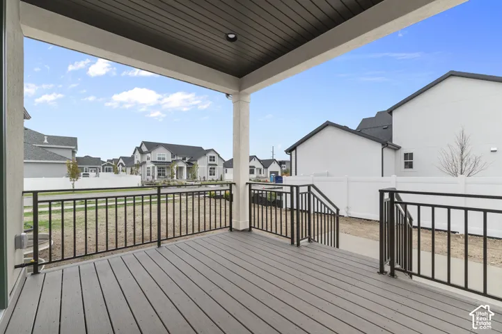 Covered patio featuring wood-finish decking, recessed ceiling lighting, and metal perimeter railing with stairs