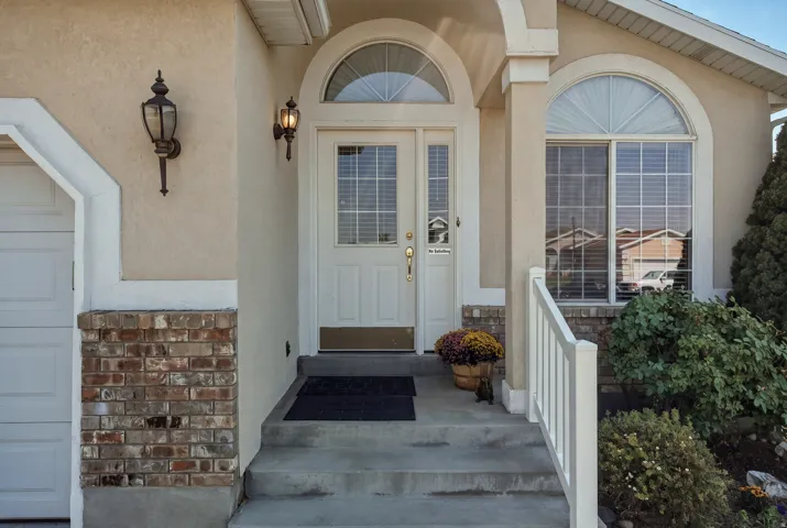 Welcoming front entry featuring a arched transom window, dual French doors with sidelights, and brick veneer detailing
