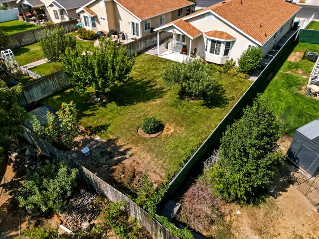 Expansive grassy yard with mature trees and a fenced perimeter
