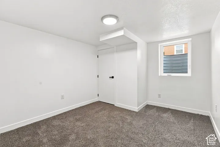 Recessed window, white trim, wall-mounted light fixture, carpet flooring, and white walls
