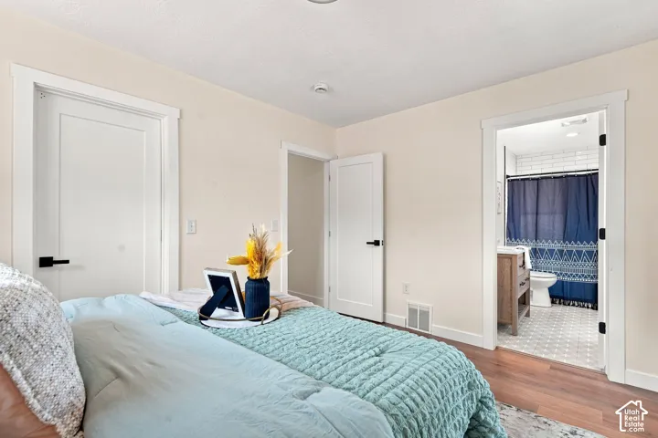 Wood-finish flooring, white trim, and doors with matte black hardware