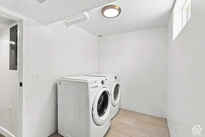 Laundry area featuring tile flooring, white walls, and an overhead flush-mount light fixture