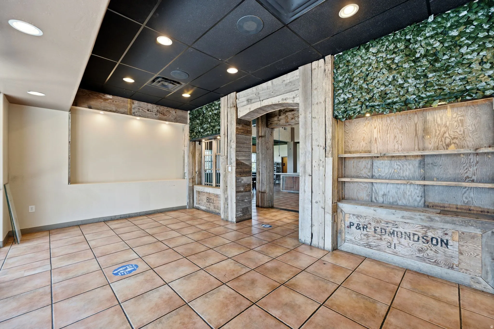 Tiled flooring with a wood-finish archway, integrated recessed lighting, and built-in shelving