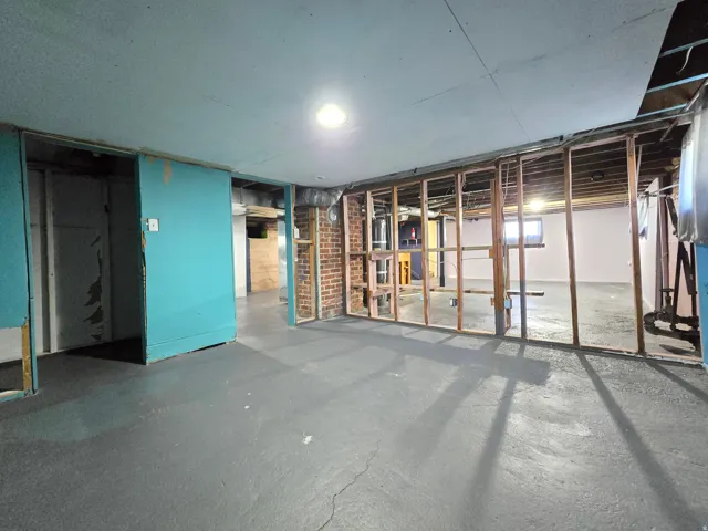 Exposed brick wall, recessed lighting, concrete flooring, wood framing, panel walls