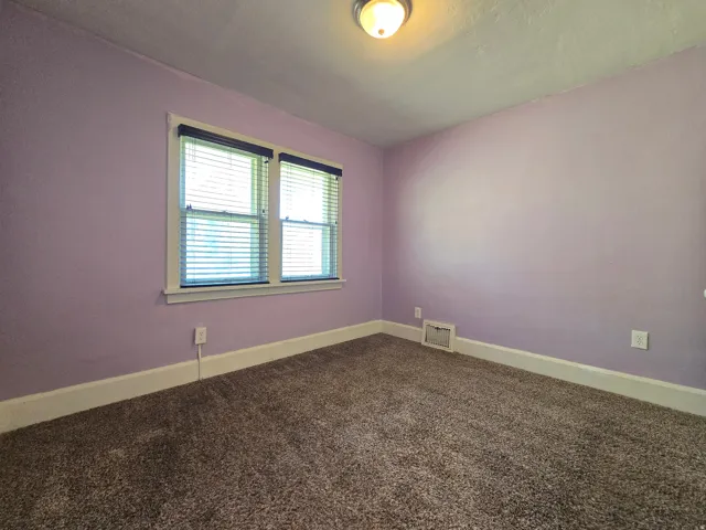 Wall-to-wall carpeting with light-toned walls, white trim, and a flush mount ceiling light fixture