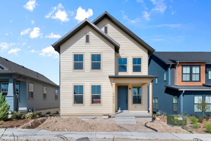 Two-story exterior with horizontal siding, covered front entry, and dark-framed windows