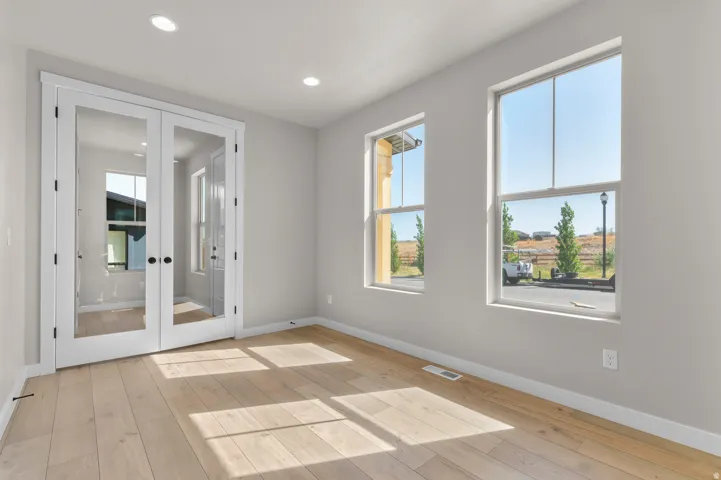 Recessed lighting, wood-finish flooring, and white trim throughout