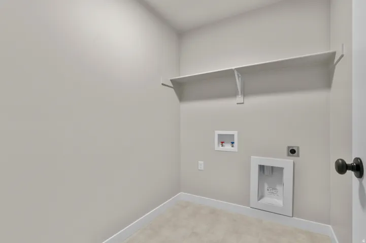 Laundry area featuring wall-mounted shelving, appliance hookups, and light-toned flooring