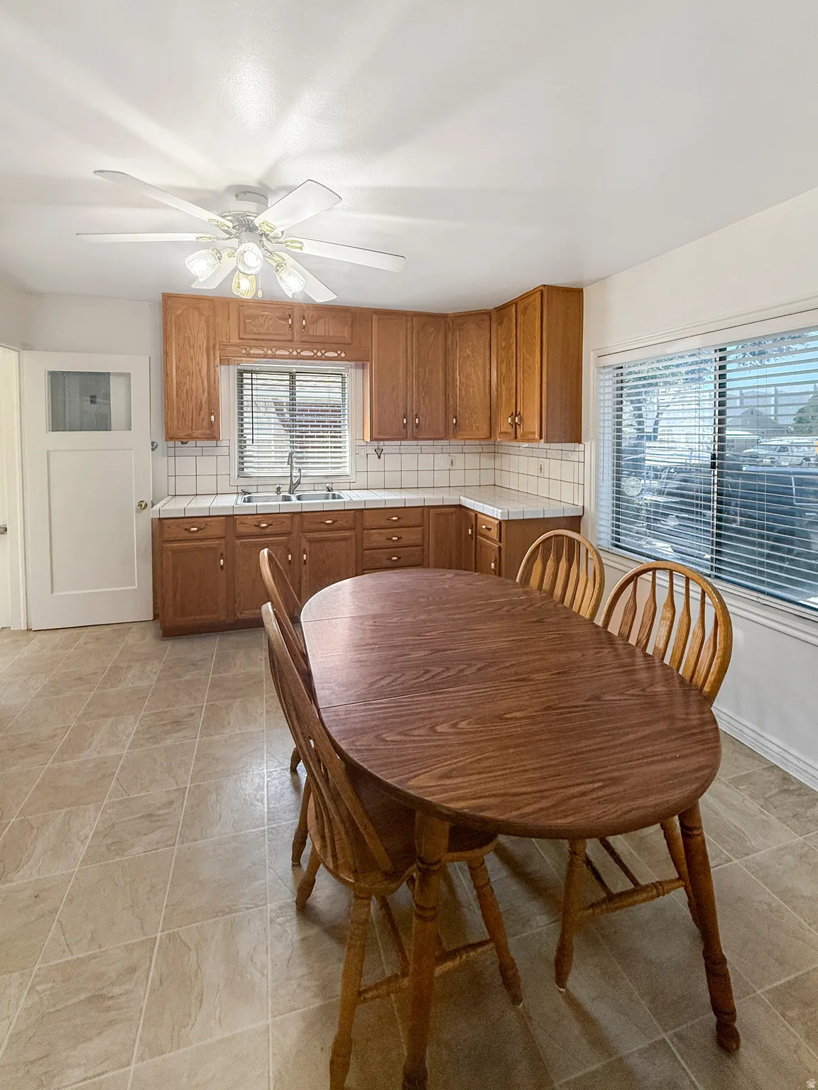 Kitchen area featuring wood cabinetry, a double basin sink, and a tiled backsplash