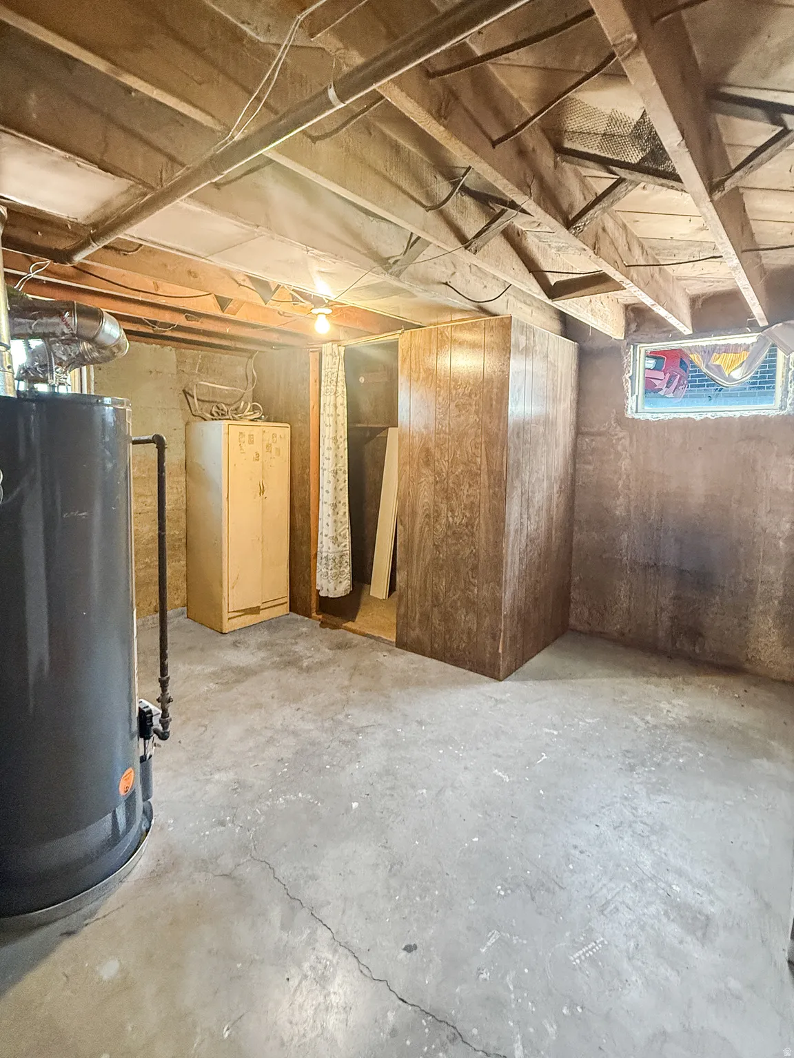 Basement area featuring exposed wood ceiling joists and concrete flooring