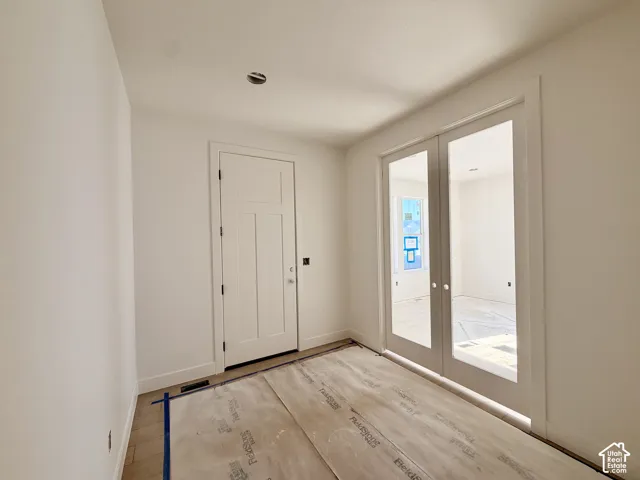 White interior walls with a three-panel interior door and a pair of French doors