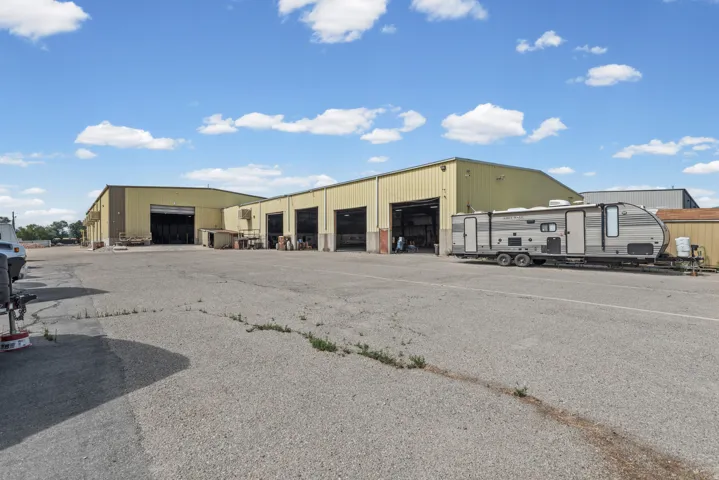 Multiple commercial buildings with roll-up doors and a paved lot