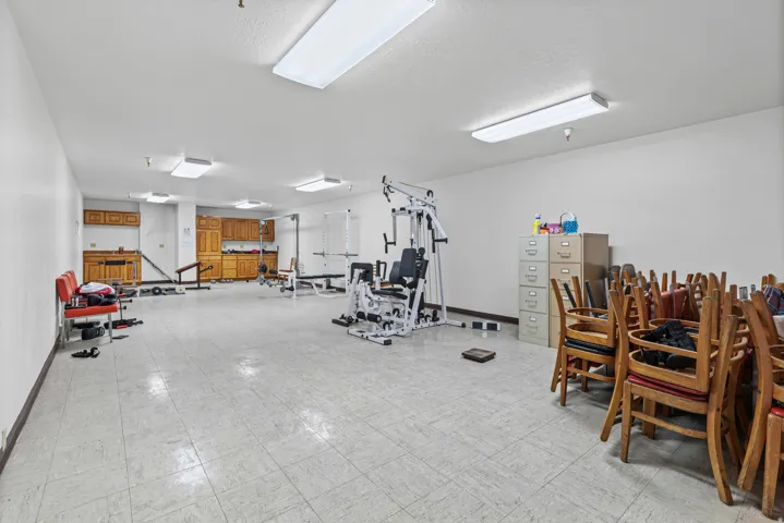Expansive room featuring tile flooring, extensive wall space, and integrated cabinetry