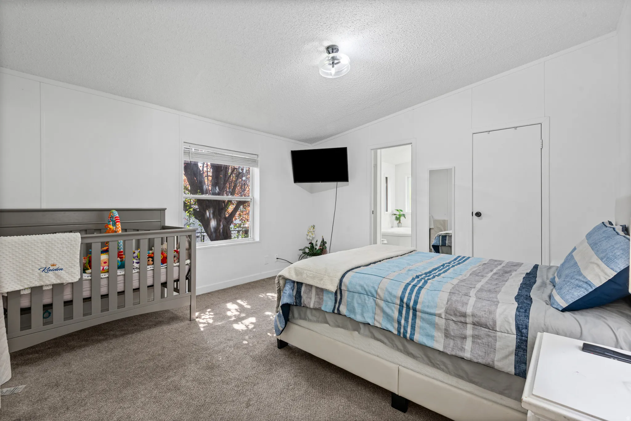 Master bedroom - Carpeted flooring, a window offering natural light, white painted walls, a flush-mount ceiling light fixture, and a built-in closet