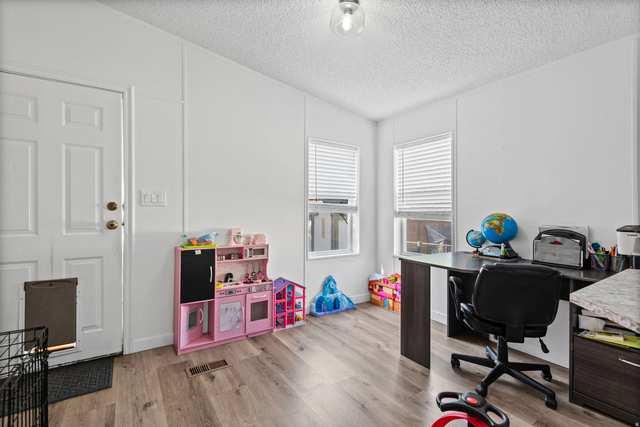 Wood-finish flooring, white walls, and a ceiling-mounted light fixture