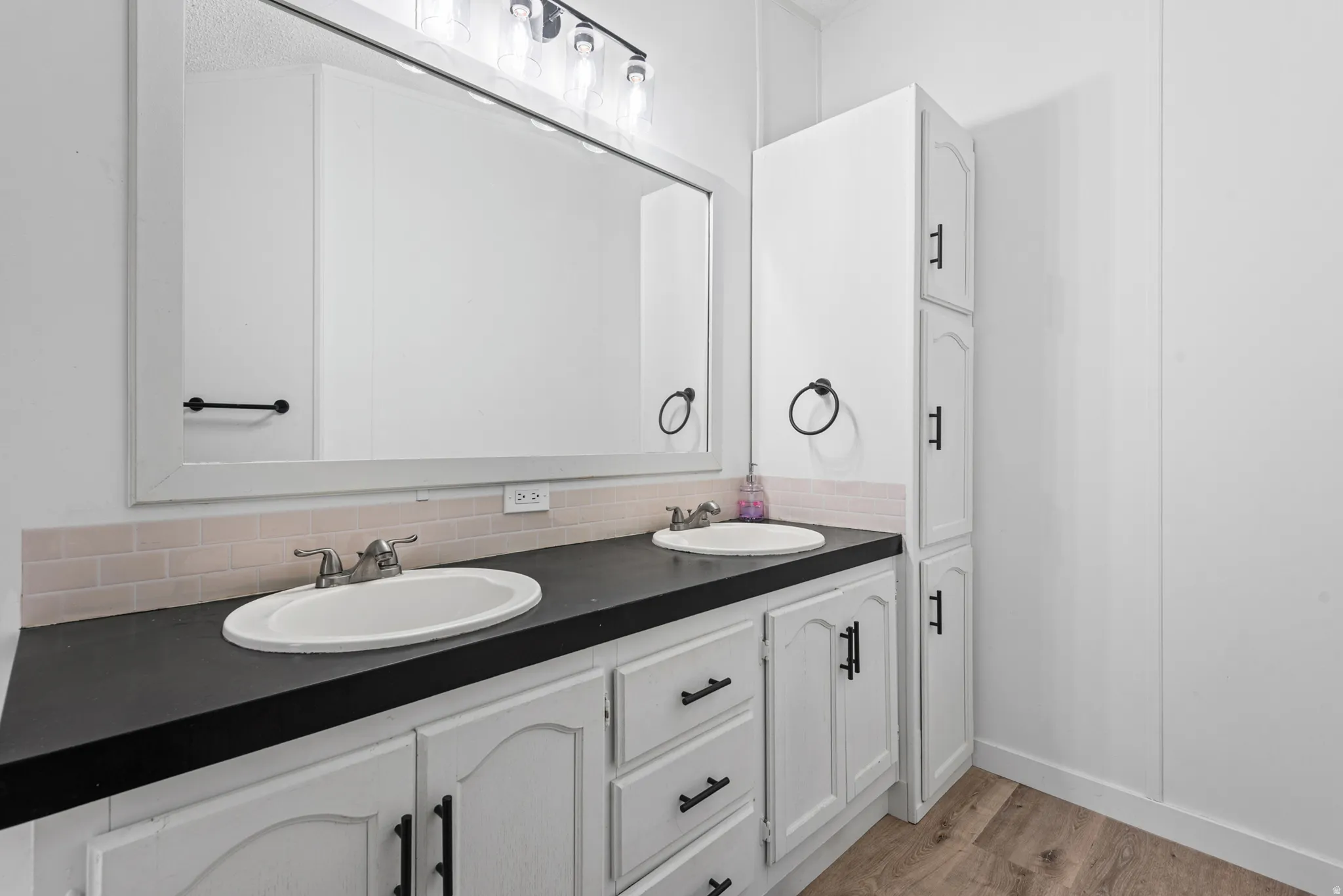 Master bedroom's bathroom - Dual vanity with white cabinetry and black countertops