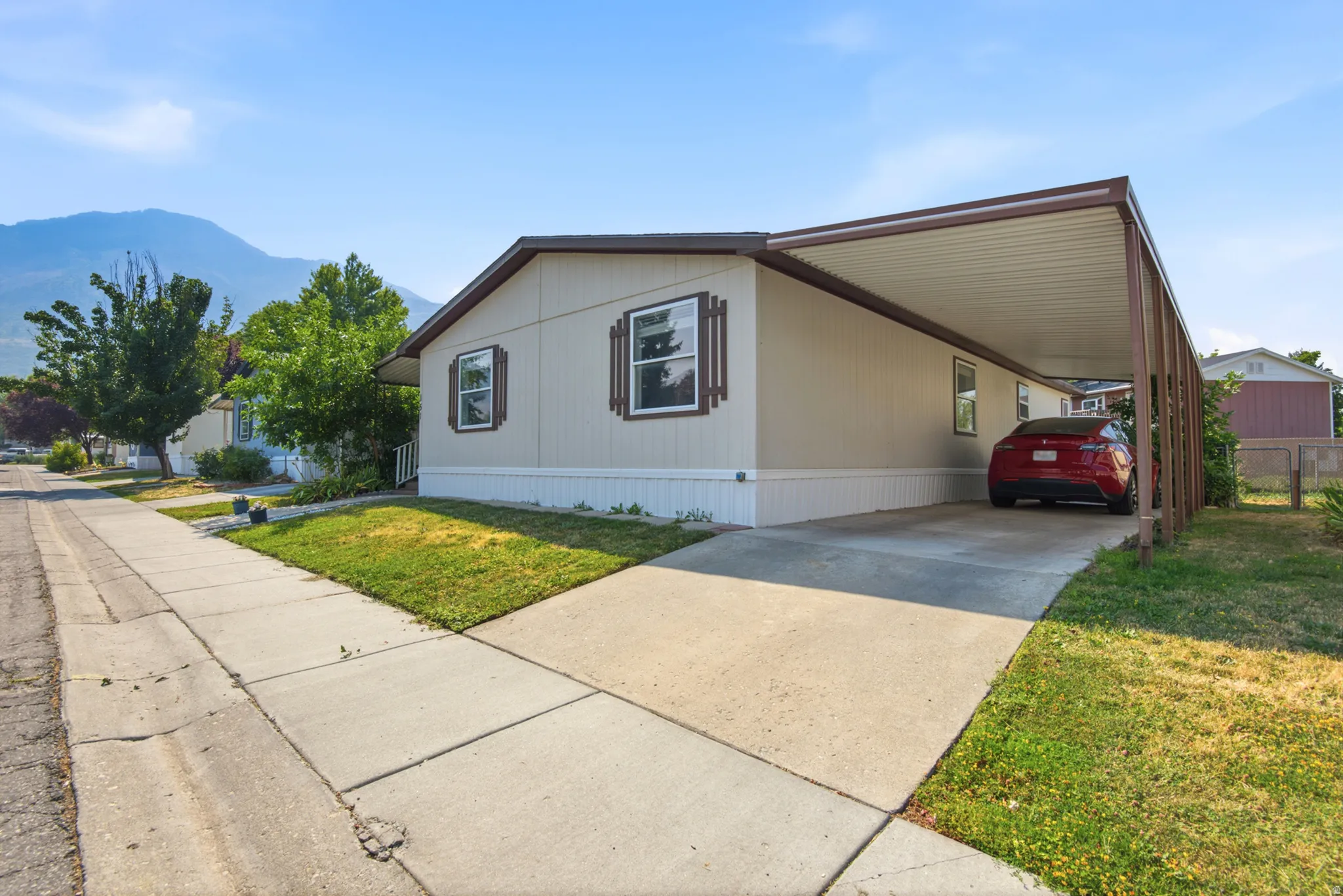 Single-story residence with a carport, concrete driveway, and a front lawn