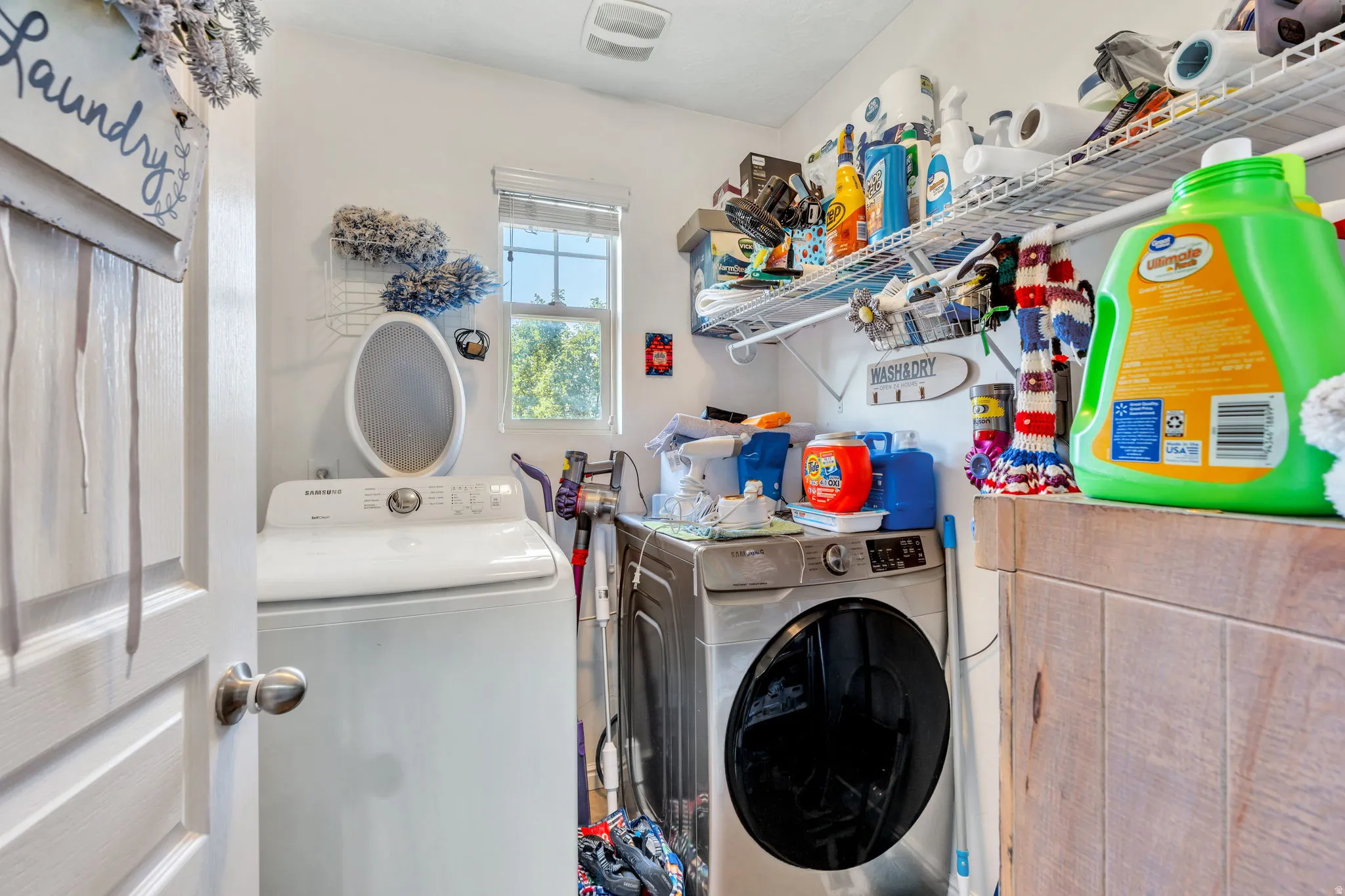 Laundry room featuring a window, wire shelving, and wood-finish paneling