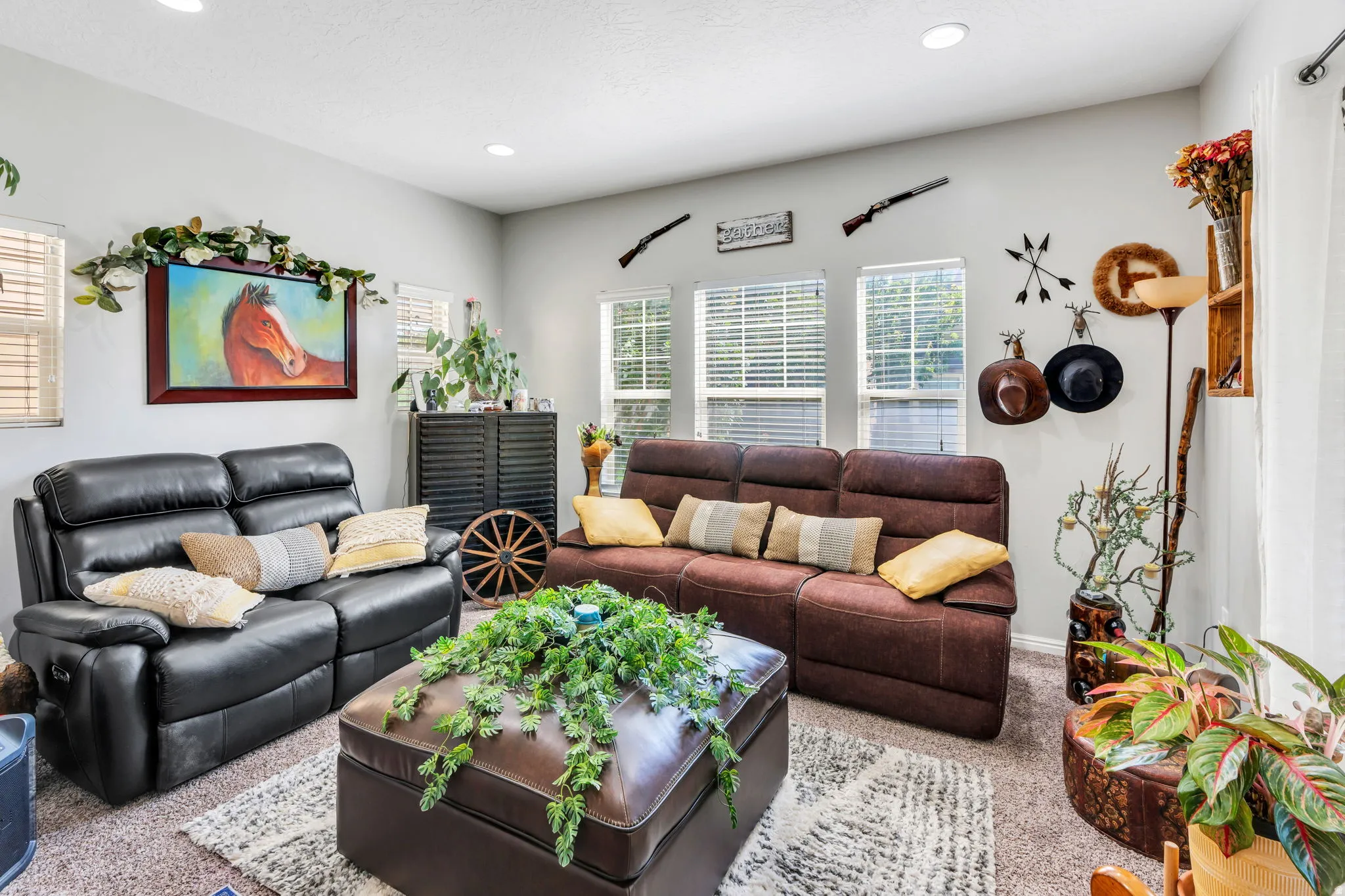 Recessed lighting, multiple windows with blinds, and textured carpeting