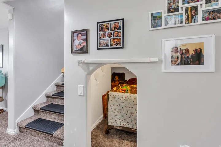 Carpeted staircase with risers, white baseboards, and a rounded archway