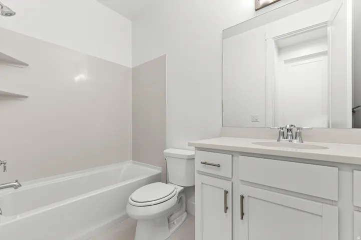 White vanity with chrome hardware, an integrated sink, and a framed mirror