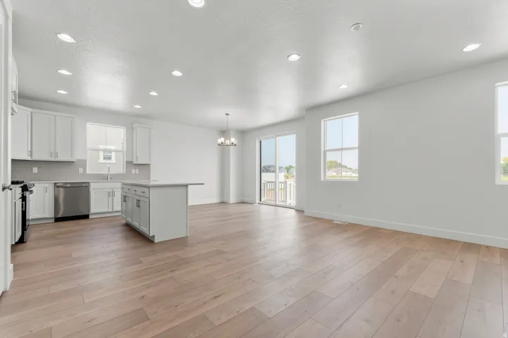 Open concept living space featuring wood-finish flooring, recessed lighting, and a modern kitchen with a center island
