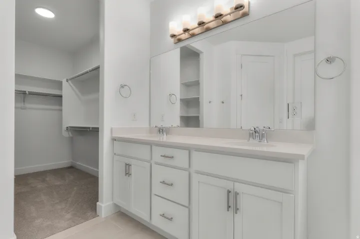 Double vanity with light-toned countertop, dual undermount sinks, and chrome faucets