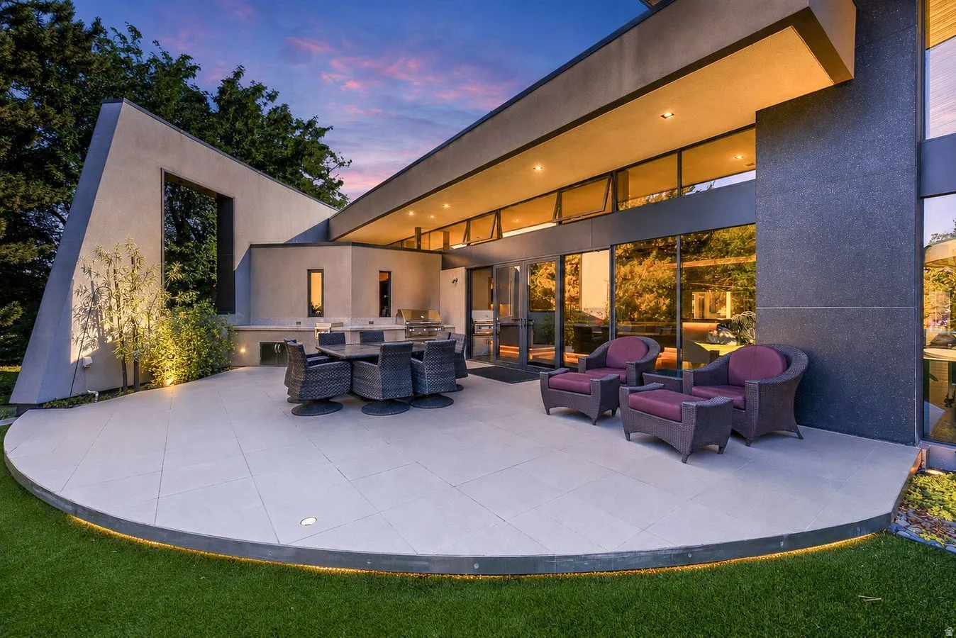 Expansive exterior patio with a curved edge, integrated perimeter lighting, and large format tile
