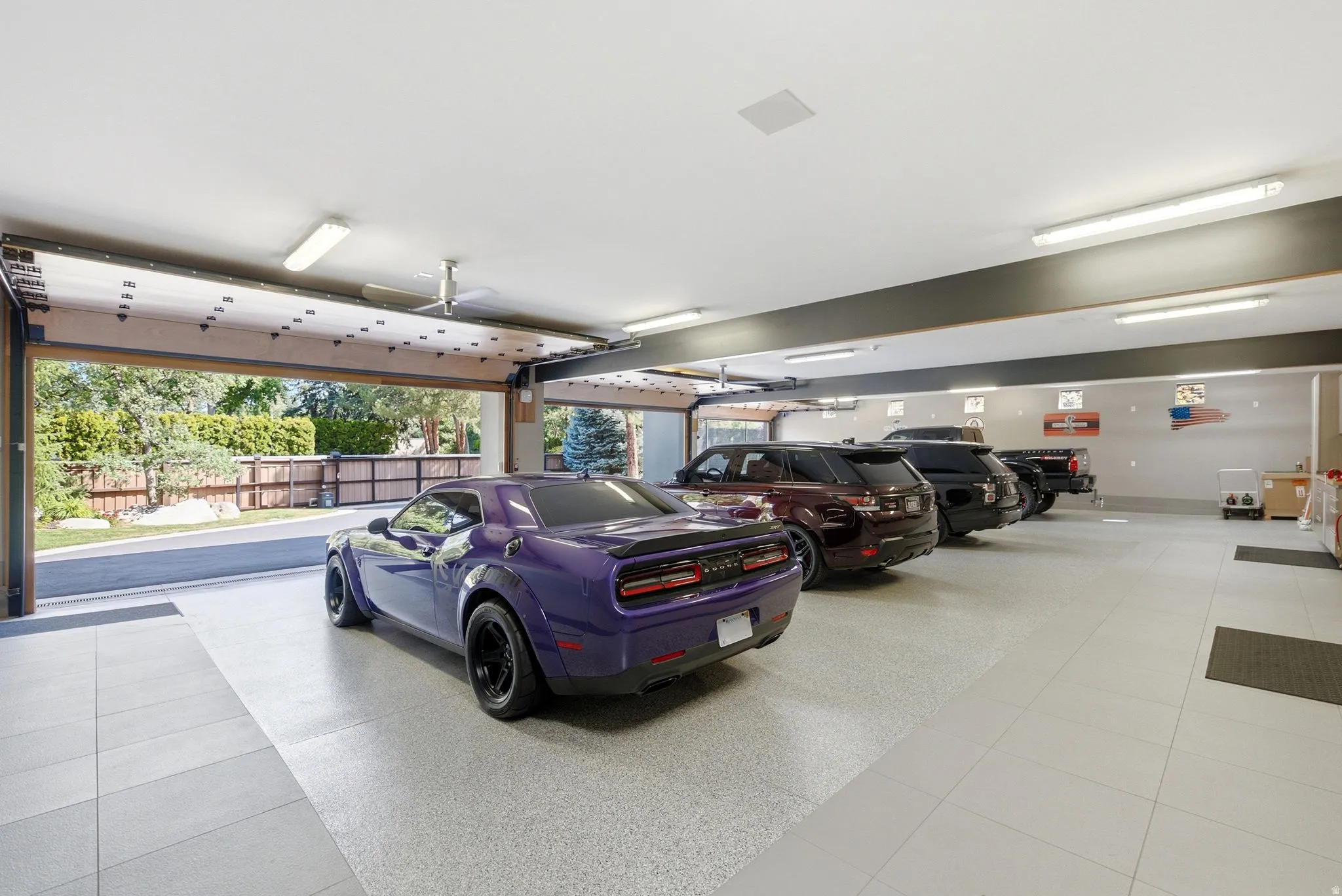 Spacious climate-controlled garage featuring polished concrete flooring, bright LED lighting, and overhead door with windows