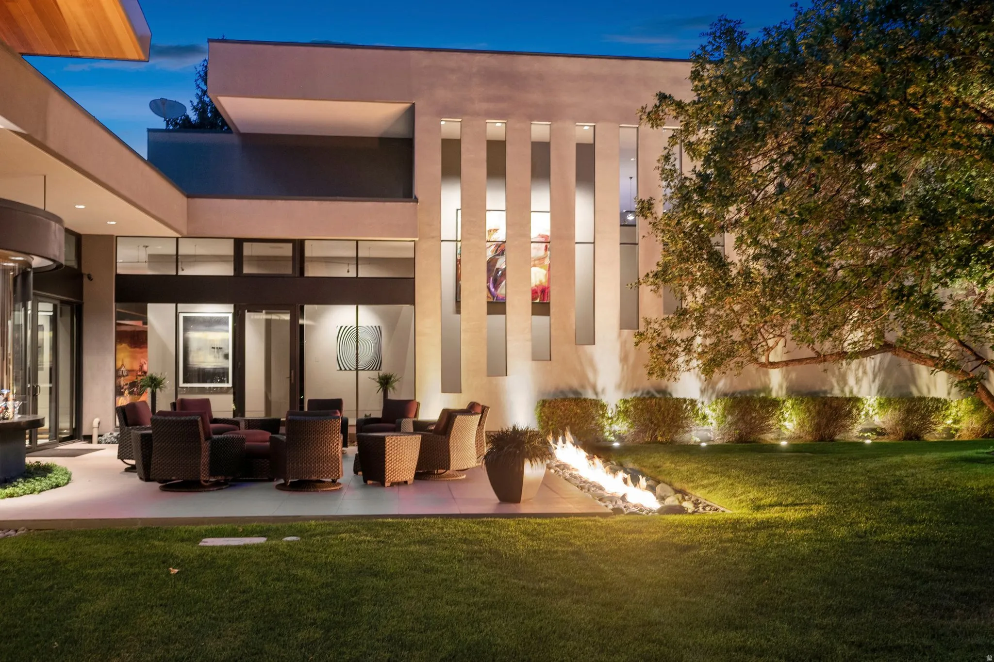 Expansive lawn with a modern fire pit feature, surrounded by mature trees and landscaping