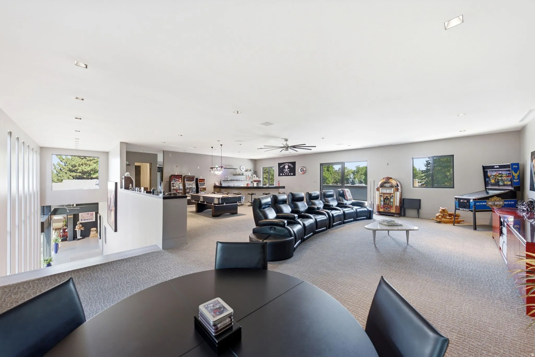 Expansive room featuring carpeted flooring, recessed lighting, and multiple windows