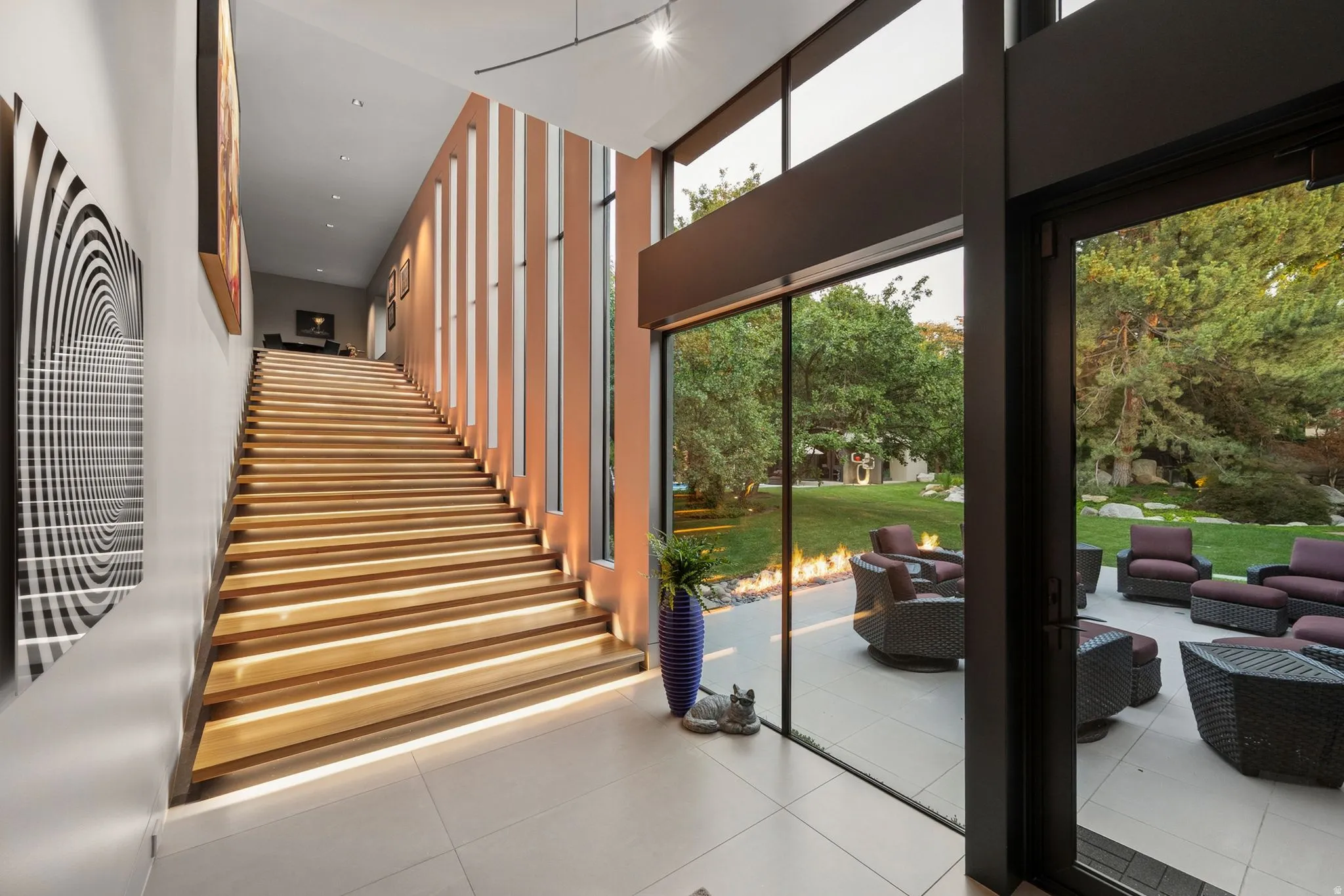 Expansive patio featuring a fire element, direct outdoor access, and mature landscaping
