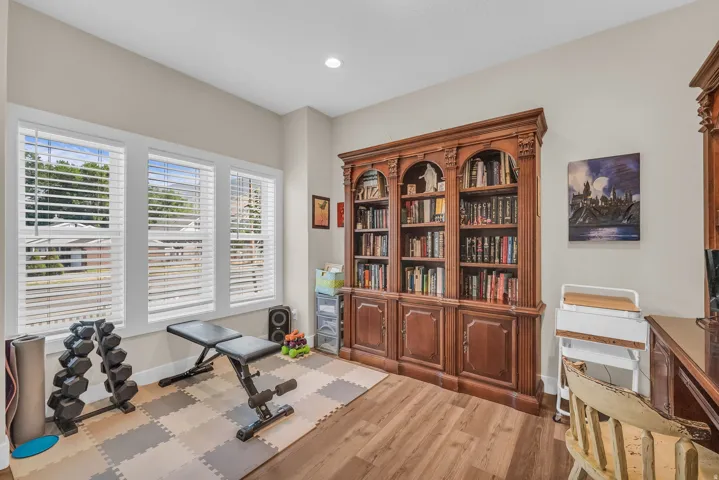 Office with wood-finish flooring, recessed lighting, and multiple windows with blinds