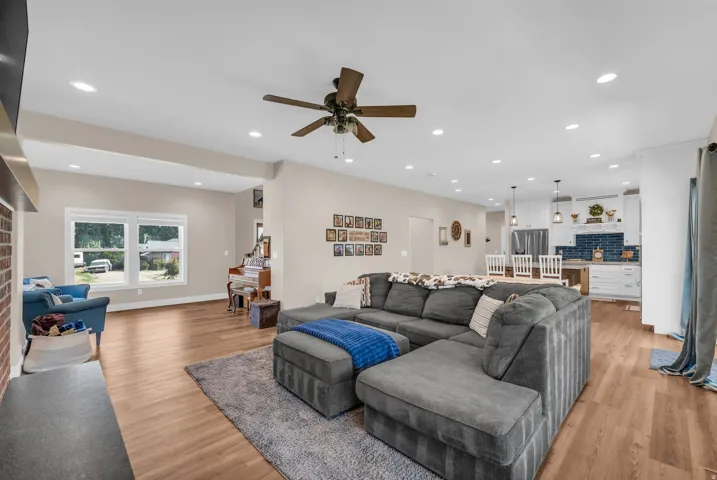 Open-concept living space featuring wood-finish flooring, recessed lighting, and a ceiling fan